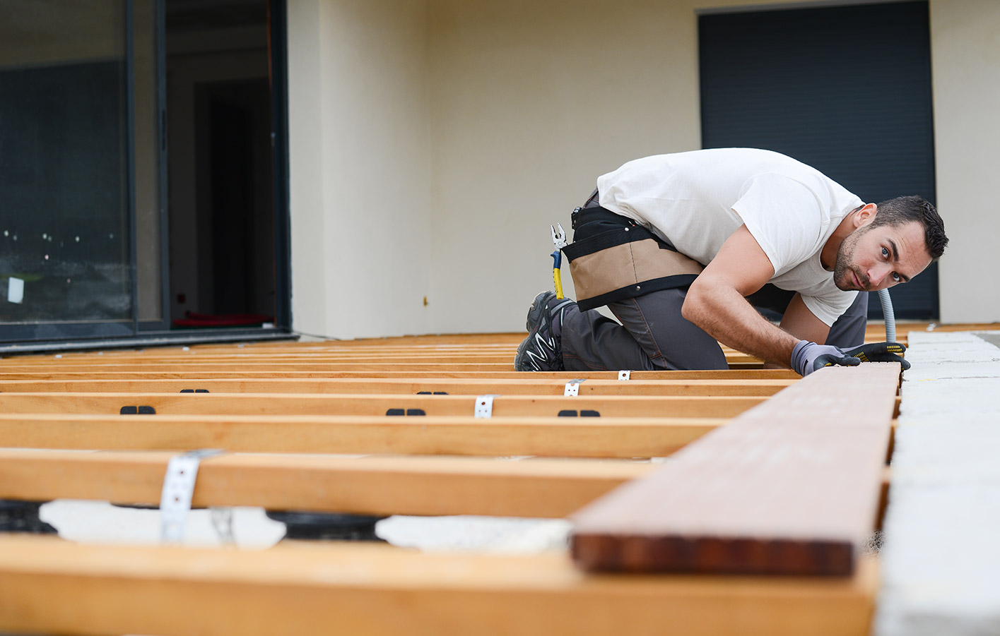 Handwerker montiert und verlegt eine Holzterrasse